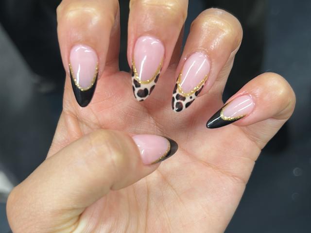 NashiroSakuraii's hand with pink nails, black tips, and leopard print designs at the tips, featuring gold accents. Boobs aren't visible.