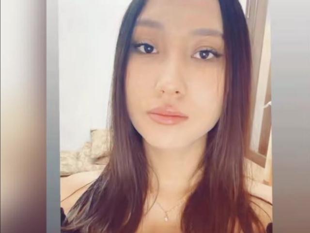 AndrianaFive has long brown hair, light skin, and is wearing a necklace with a small pendant. She's looking at the camera with slightly pouty lips.