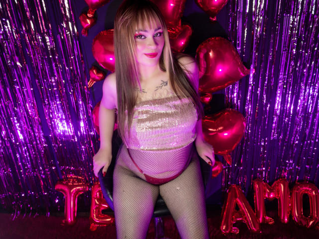 LailaDurmont with long brown hair, wearing a sparkly pink tube top, fishnet tights, and red heart balloons, sitting on a stool, showing her big tits and shiny ass.