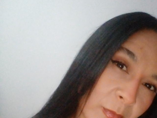 AileenRamirezW's face with long black hair, brown eyes, and subtle makeup, showing a slight smile, with a light skin tone and a small nose. Her lips are glossy.