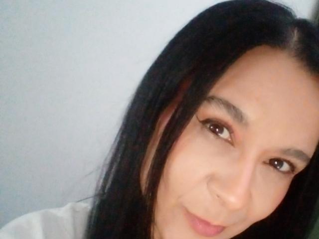 AileenRamirezW has long black hair, brown eyes, and a slight smile, with a small nose ring and light makeup, showing a cute, pretty face.