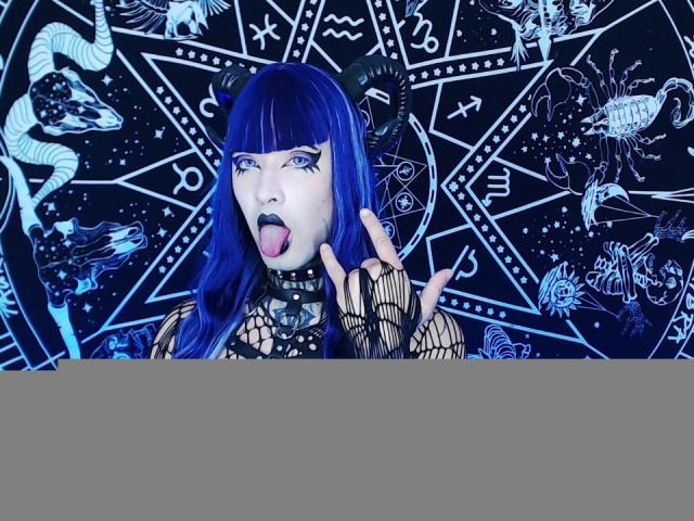 NaomyWoman with blue hair, black fishnet top, and choker, sticking out tongue, middle finger up, showing off tits, wearing fingerless gloves, against a cosmic, mystical backdrop.