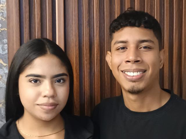 SofiAndLuis, with long black hair and brown eyes, stands next to Luis, who has short curly black hair and a goatee, both smiling at the camera.