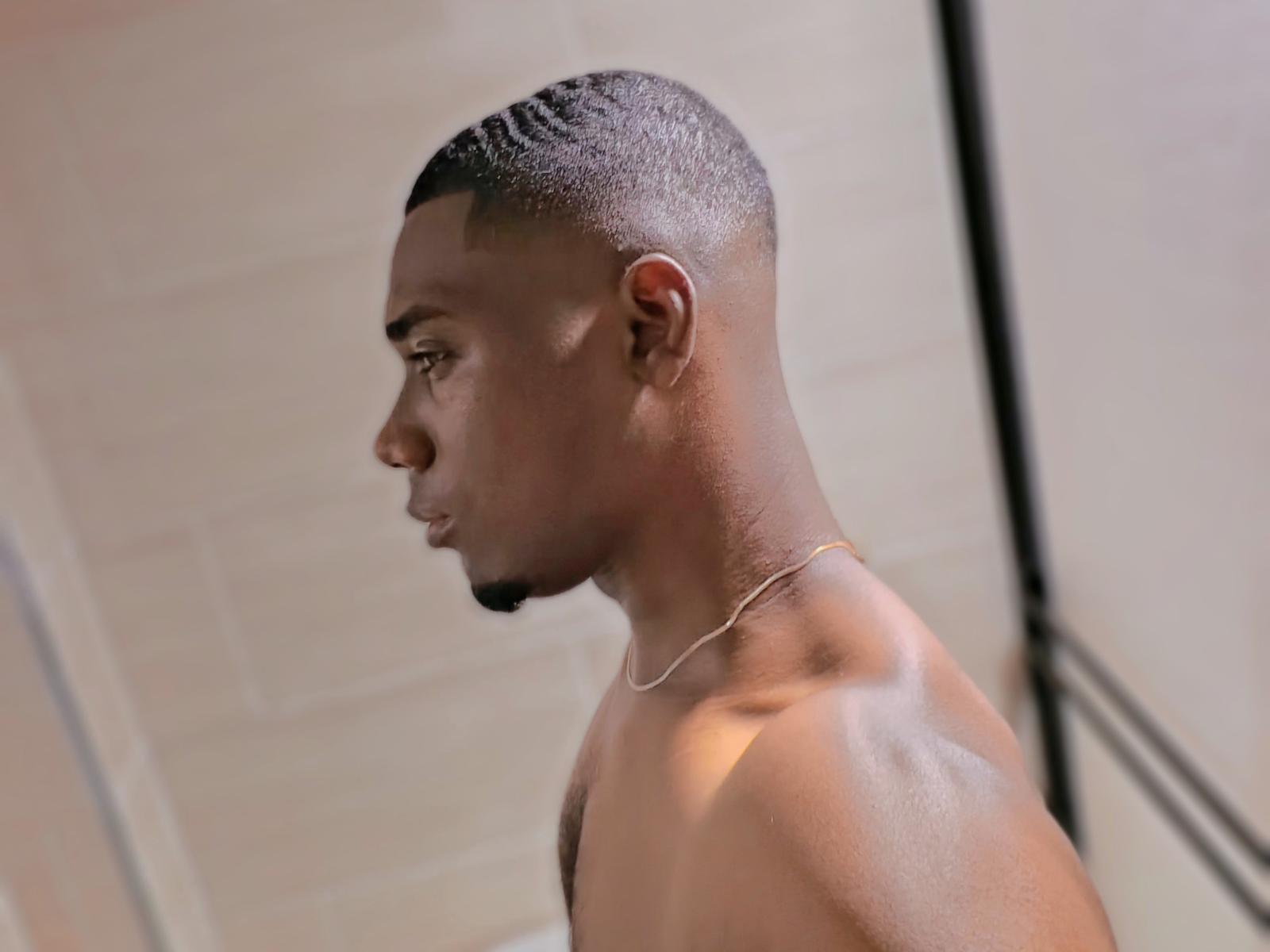 Lycus has a smooth, dark brown skin tone, short black hair, and a thin goatee. He's shirtless, wearing a thin gold chain, and looking to the side.