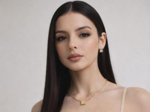 IsabellaJames has long, straight dark brown hair, light skin, and is wearing a gold necklace with a small square pendant. She has full lips, subtle makeup, and earrings.