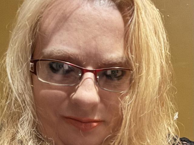 Cherish Williams tiene el cabello rubio claro, gafas con montura roja y una ligera sonrisa. Se pueden ver sus ojos azules y su piel clara. Sus pequeños senos están parcialmente cubiertos por su cabello..
