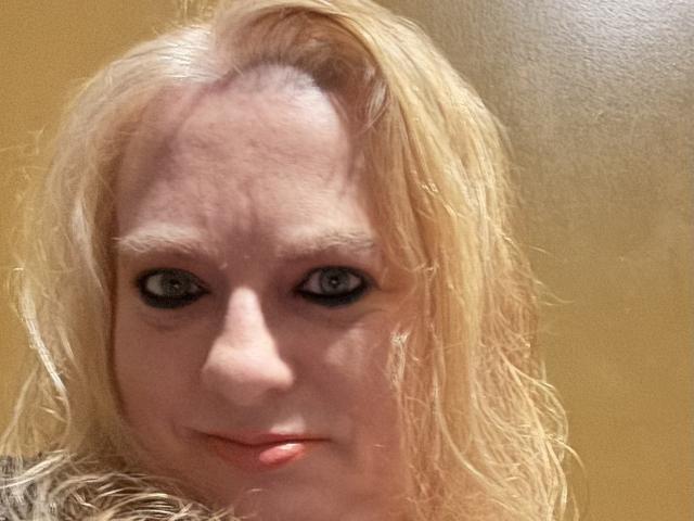 Cherish Williams hat eine helle Haut, blaue Augen und blondes, feuchtes Haar. Ihre leicht geöffneten Lippen zeigen ein kleines, kaum wahrnehmbares Lächeln. Sie hat sichtbare Falten auf der Stirn..