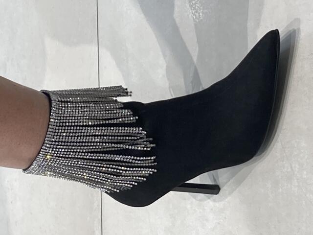 DeesseBleue's black, pointed-toe boot with a silver, bejeweled cuff that has hanging, sparkling chains covering her ankle.