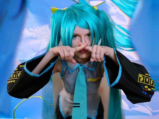 LinaVeritas, vestindo rabos de cavalo turquesa e uma roupa Vocaloid preta e verde-água, faz um sinal de paz com os dedos. lábios, olhos azuis intensos fixos à frente. Fundo azul neon vibrante.