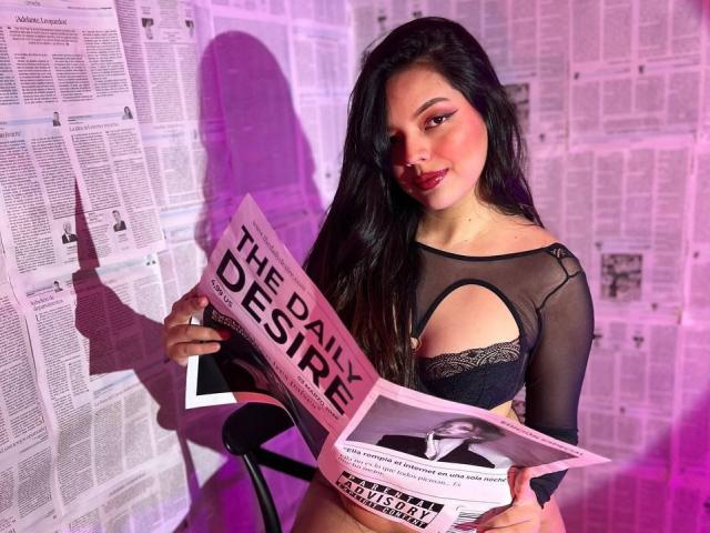 ViolettaRouse, sexy brunette with long hair, wearing a black mesh top with cutout, holding "FEDERAL DESIRE" magazines, pink and purple lighting, shadow on wall, provocative pose, seductive expression.