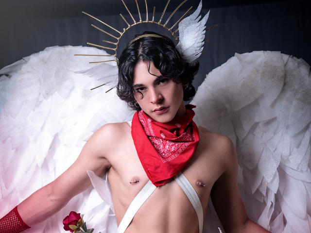 Luke Howlandy, com pele clara e cabelo preto curto, usa um lenço vermelho e uma alça branca, tem asas de anjo e um halo radiante. e uma rosa. Incrívelmente sexy, quase nua, com piercings nos mamilos..