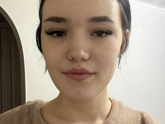 Winifred Kortright tiene la piel clara, cejas oscuras, largas pestañas negras, una nariz pequeña y labios rosados. Lleva un suéter beige, y su cabello negro está ligeramente despeinado..
