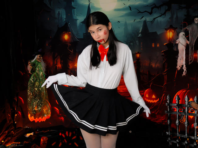 Digitale Kunst von ZoeWinfrey, eine asiatische Frau mit langen, schwarzen Haaren, einer weißen Bluse, einem roten Schleifchen, einem schwarzen Rock, weißen Handschuhen. stehend in einer dunklen, gotischen Stadtlandschaft mit leuchtenden Kürbislampen und Fledermäusen. Verführerische Pose.