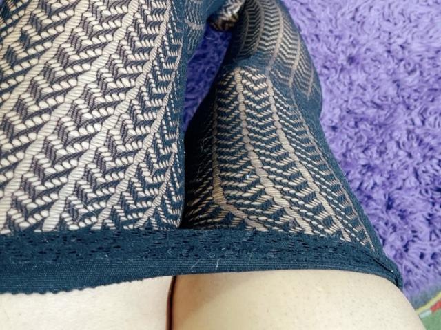 Close-up van het onderlichaam van Cincia69, gekleed in zwarte, kanten leggings met een patroon. Haar benen zijn gespreid, waardoor haar blote, bruine billen zichtbaar zijn. De getextureerde kant creëert een sexy, uitdagende uitstraling..