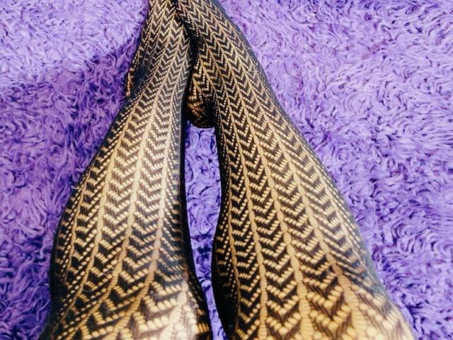 Close-up van twee grote, gemerkte insecten vleugels met zwarte en gele zigzag patronen, die aan de bovenkant samenkomen tegen een gestructureerde, paarse, pluizige achtergrond. De vleugels vormen een suggestieve V-vorm..