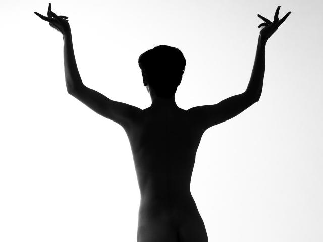 Silhueta de LissyLuxe, levantando as duas mãos com os dedos formando símbolos de paz. Figura preta e sólida contra um fundo branco. Sem características visíveis, mas a pose sugere uma vibração confiante e enérgica. Alto contraste.