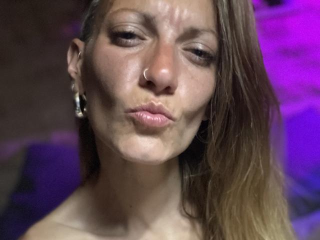 DaneeSoHot's puffy, shiny face with closed eyes, nose ring, and slightly parted lips making a pouty expression. She has long, wet brown hair and silver earrings.