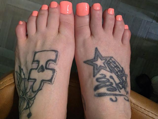 PebsStayThnx's feet with neon pink nail polish, showing tattoos: a bold "F" with leaves on the left and a star owl with branches on the right.