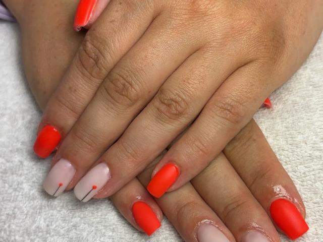 Two hands rest on a white towel. AmmaFrancaise's nails are polished in bright red and nude with small red dots. The red nails are matte with a slightly rough texture, while the nude nails are glossy. The nails are neatly aligned, with the red nails on the left and the nude nails on the right. The skin is light brown. The hands are slightly overlapped, showing a contrast between the matte and glossy textures.