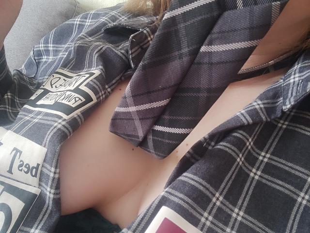 MinistraX's chest is exposed with a plaid shirt covering her tits, showing a small bit of pale skin and a dark purple tie draped over her.