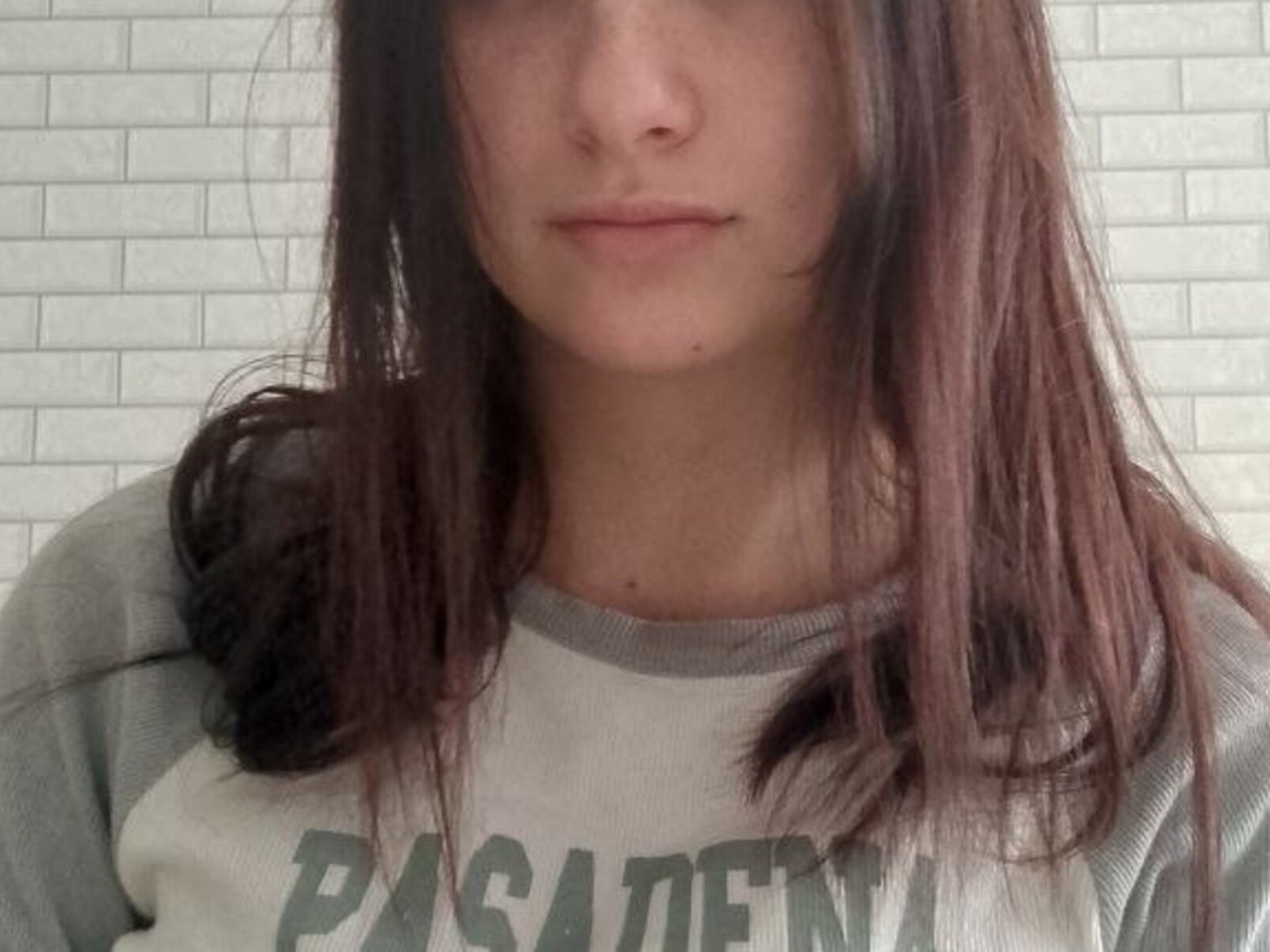 LoretteSligh with straight brown hair, subtle nose ring, and a gray/white "Passent" shirt, showing a neutral expression, no visible tits or ass.