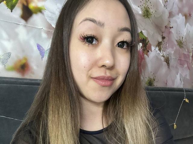 Digital illustration of a Japanese-style fan with a large, soft pink and white center. Thin, vertical lines extend from the bottom, creating a textured, rib-like pattern. Minimalist design.