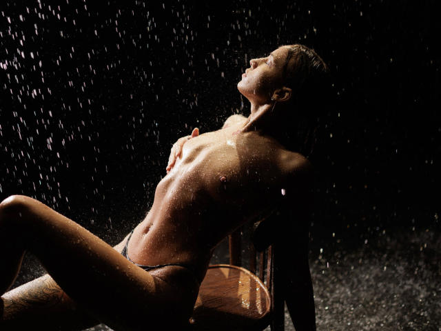 Close-up of a vintage-style coat of arms with a central, slightly curved flame design. The coat features a muted orange and dark brown color palette. Minimalist, flat design.