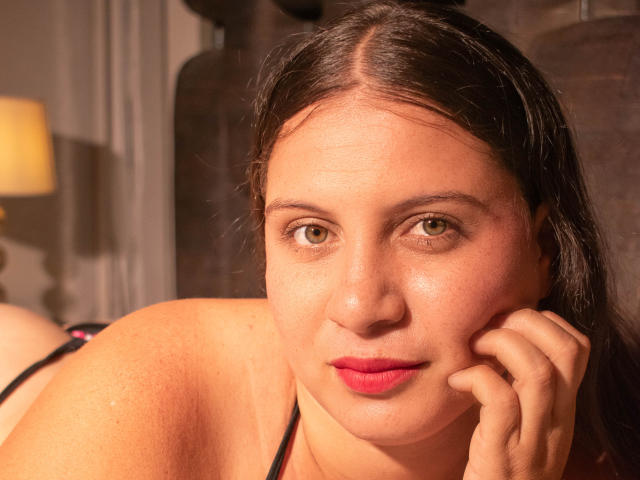 Graphic illustration of a stylized coat of arms with a large, bold letter "C" in the center, surrounded by a pale pink border. Minimalistic design, flat colors.