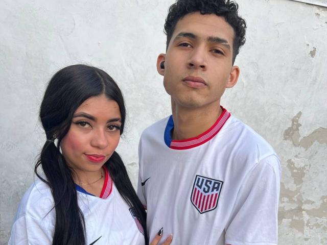 TheInnocentOfSnake, a Latina girl with pigtails and red lipstick, stands next to a curly-haired, brown-skinned boy in white soccer jerseys, both with serious expressions.