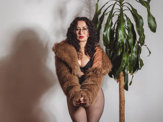 Three-dimensional, modernist style logo with bold, flat colors. Central, dark green emblem with red and white accents. Minimalistic, geometric design. Large, stylized letter "A" at top right.