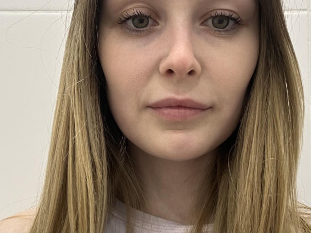 AnnamariaVillarin's face with light brown eyes, straight blonde hair, and pale skin. She has small, slightly pink lips and a neutral expression. Her nose is small and button-shaped.