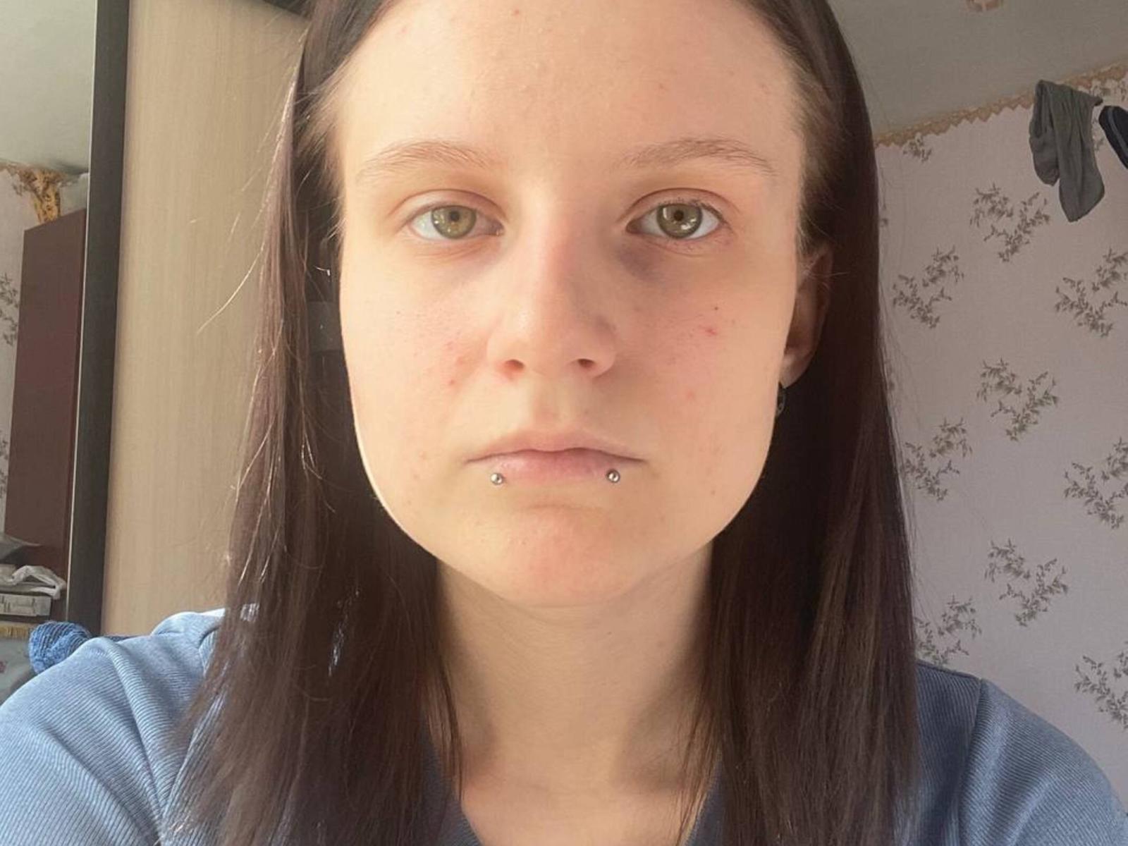 AkikoGamons a la peau pâle, les yeux verts et les cheveux bruns et lisses. Elle porte une chemise bleue et a un piercing sur la lèvre inférieure. Son visage présente quelques imperfections et elle a l'air sérieuse..