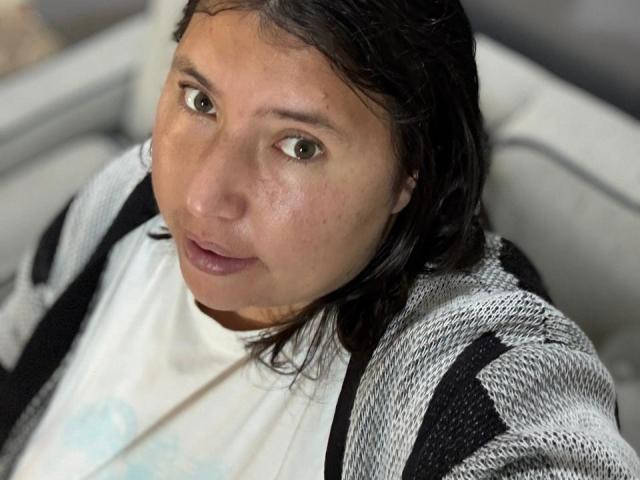 BiancaValli ha un viso leggermente arrossato, occhi marroni, capelli neri e lisci, e indossa un cardigan a righe bianche e nere sopra una camicia bianca. Le sue labbra sono naturalmente rosa..