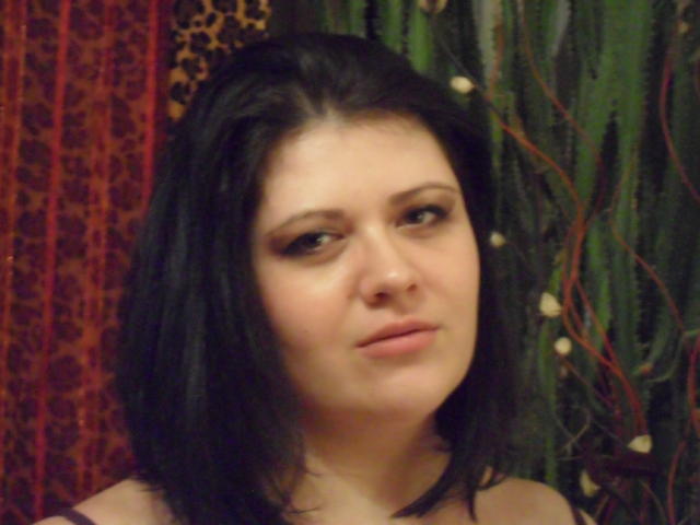 Carolina69 ha i capelli scuri, lunghi fino alle spalle, la pelle chiara e un trucco leggero. Il suo naso piccolo e la sua espressione neutra sono evidenti. Indossa una maglia scura e guarda leggermente di lato..