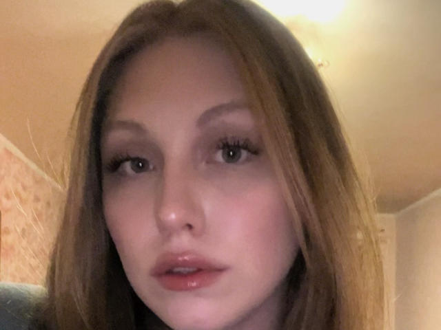 MelinaBoye's face, pale skin, brown hair, slightly parted pink lips, subtle makeup, dark eyebrows, soft light, slightly blurry, centered in the frame, looking slightly to the left.