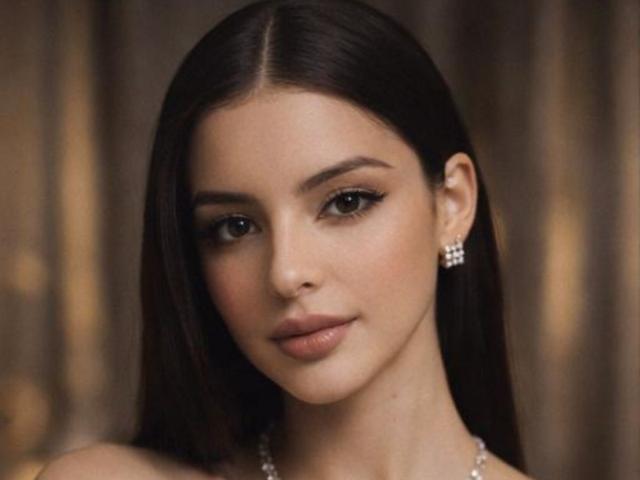 IsabellaJames has long dark brown hair, light skin, and is wearing diamond earrings with a subtle smile, looking directly at the camera with her brown eyes.