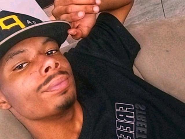 MasterXx is a black dude with a mustache, wearing a black cap with yellow "A" and black shirt, lying on a couch, arms folded, with a slight smirk.