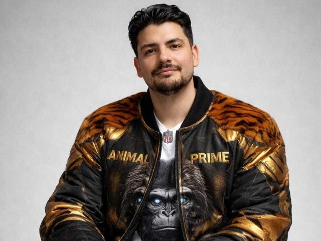 DracoSeoul with a chubby face, dark hair, beard, and a gold-and-black animal print jacket featuring a realistic gorilla face on the chest. He's looking at the camera.