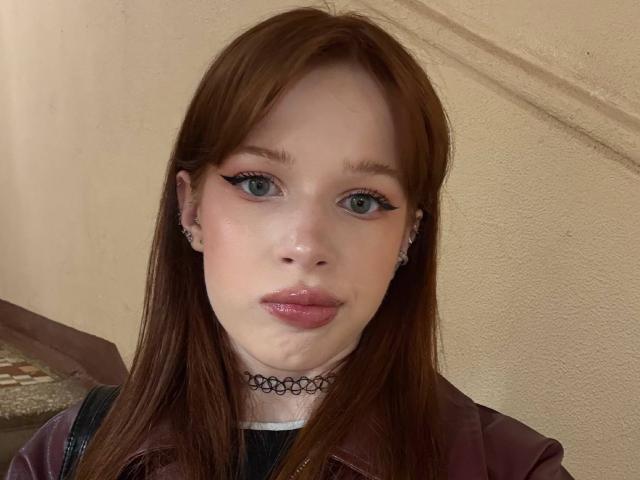 Margo Tamminen heeft lichtgroene ogen, roze lippenstift en bruin haar. Ze draagt een zwarte choker, oorbellen en een paars jasje. Haar gezicht heeft een lichte, natte vlek..