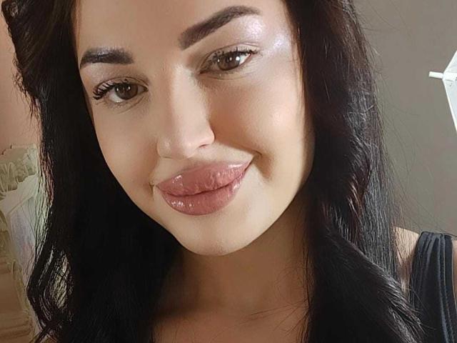 MissJaqueline heeft glanzende bruine ogen, dikke zwarte wenkbrauwen en glanzende roze lippen. Ze steekt haar tong een beetje uit. Ze heeft lang zwart haar en een schattige glimlach..