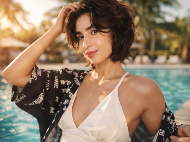 TameikaMacclellan with short brown hair, wearing a white tank top and black patterned shirt, by a blue pool, hand in hair, smiling, sunlit, looking cute with small tits.