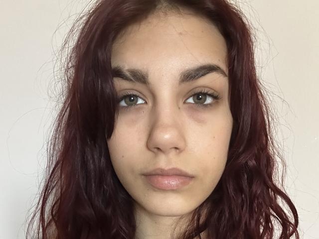 AuroraElly a les cheveux roux, ondulés et sales, des yeux verts et une expression neutre. Sa peau est légèrement marquée par des imperfections, et elle a un petit nez légèrement retroussé..