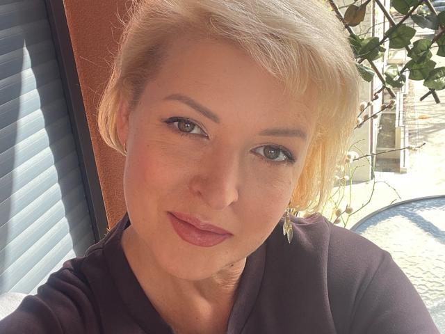 LunaxFantasy a les cheveux blonds, la peau claire, les yeux verts et porte du rouge à lèvres rose. Elle porte un haut noir et des boucles d'oreilles dorées, et elle a un léger sourire. Ses seins ne sont pas visibles..