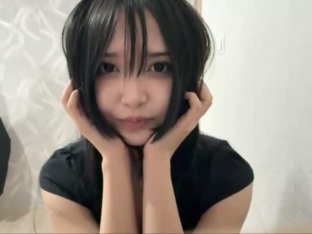 EmaVanhowe with black bob, hands on cheeks, serious expression, wearing black shirt, soft light, slight blush, pale skin, Asian, subtle makeup, cute, slightly parted lips.