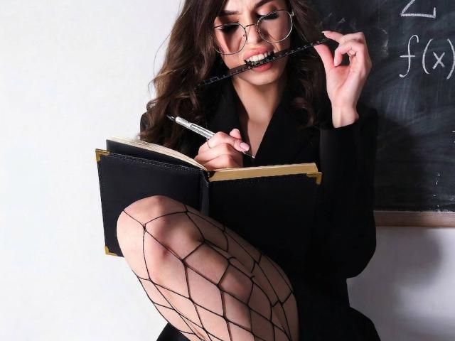 CandyCarrie with long brown hair, glasses, and black outfit, biting a pen, writing in a book, wearing fishnet stockings, showing her bare thigh and ass.