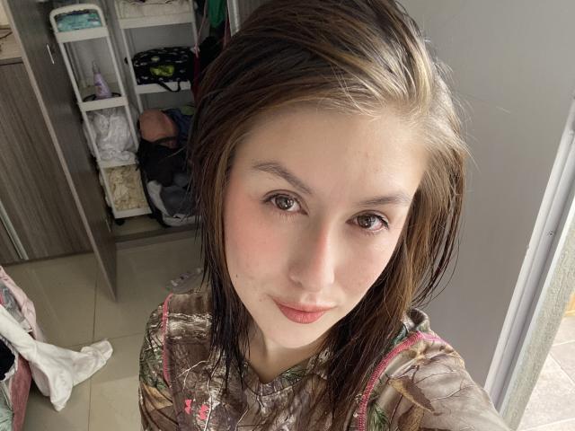 Isabella Palacio tiene el cabello castaño, ojos verdes y labios rosados. Lleva una camisa con estampado floral y tirantes rosas, y mira a la cámara con una ligera sonrisa..