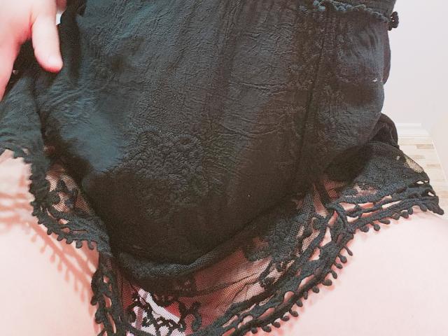 Akkanee's black lace underwear, showing her ass, with a textured fabric and delicate lace trim, her hand slightly pulling up the lace.