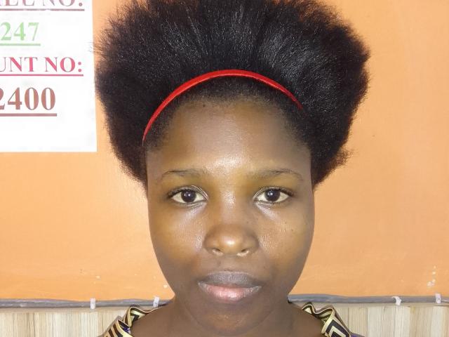Zilpah has dark brown skin, a fluffy black afro, and wears a red headband. Her brown eyes and slight smile are visible. She's dressed in a zebra-patterned top.