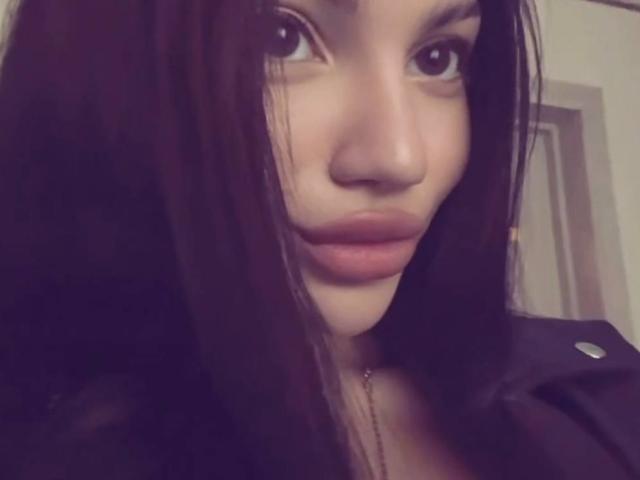 Het gezicht van Natalia Liukko, met donkerbruine ogen, volle roze lippen en lang zwart haar, gekleed in een zwarte top, kijkt iets omhoog, in een zachte, licht onscherpe selfie..