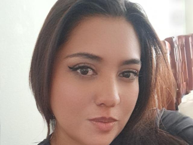 PaulaAnd has brown hair, dark eyeliner, and full lips. Her brown eyes and light skin are visible. She's looking directly at the camera with a slight pout.